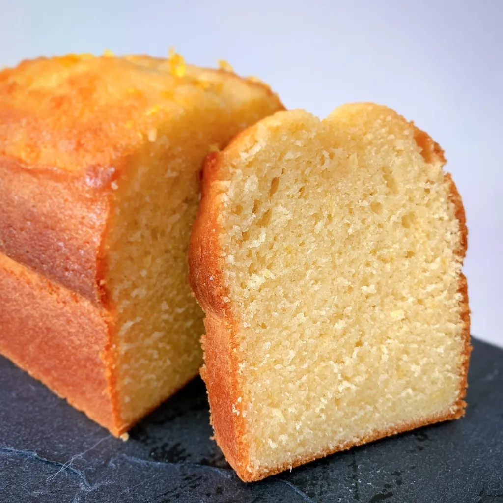 Cake au citron, décoré par des zestes de citron jaune, pris un photo sur une ardoise