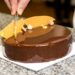 Entremet glacé en couloir chocolat lait, décoré de coraux de chocolat dulcey, étant entrain d'être décoré avec des feuilles d'or et des fruits caramélisés